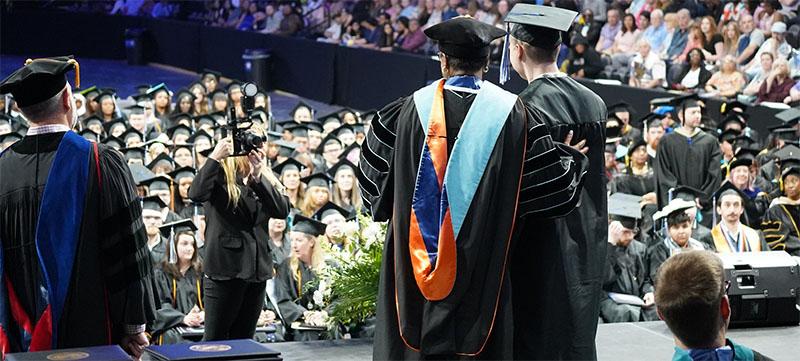 2023年毕业典礼回顾——一位刚毕业的学生在毕业典礼上停下来与校长合影.